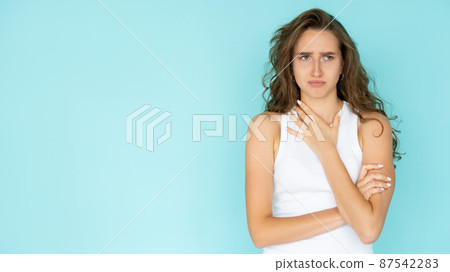 Disappointing situation. Displeased woman. Regretful feelings. Upset pretty lady in white dress crossing hands on chest isolated blue copy space. 87542283
