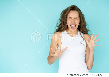 Excited happiness. Expressive woman. Winner success. Pretty emotional screaming lady hands up closing eyes isolated blue copy space. 87542285