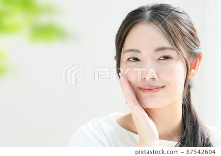 一個臉上掛著美麗微笑的日本女人,很容易用於美容 複製空間與前模糊 綠色 一個臉上掛著美麗微笑的日本女人,很容易用於美容 複製空間與前模糊 綠色 87542604