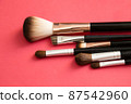 Makeup brush on red background 87542960