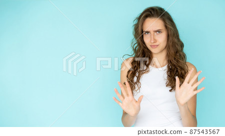 Protesting gesture. Disagreed woman. Negative answer. Upset gloomy lady holding hands up expressing disappointment isolated blue copy space. Protesting gesture. Disagreed woman. Negative answer. Upset gloomy lady holding hands up expressing disappointment isolated blue copy space. 87543567