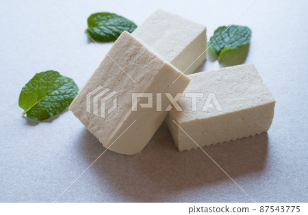 Tofu with mint leaves on wooden background. Healthy food 87543775