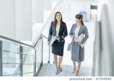 爬上商務辦公室樓梯的兩名女商人 87544040