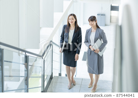 爬上商務辦公室樓梯的兩名女商人 87544041