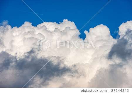 Beautiful Cumulus Clouds on Clear Blue Sky and an Airliner with Contrails 87544243