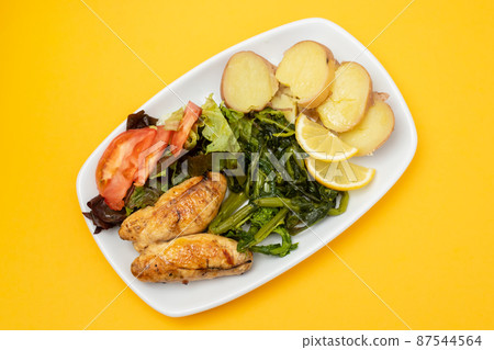 Grilled caviar cod fish with greens and fresh lemon on white small plate. Grilled caviar cod fish with greens and fresh lemon on white small plate. 87544564
