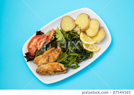 Grilled caviar cod fish with greens and fresh lemon on white small plate. Grilled caviar cod fish with greens and fresh lemon on white small plate. 87544565