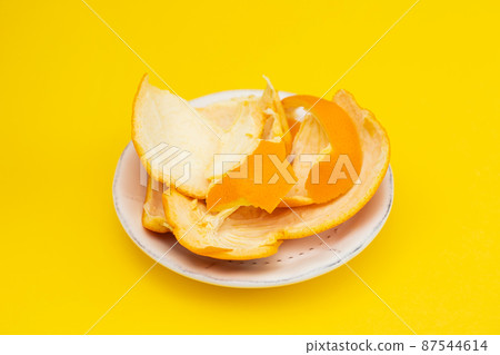 fresh orange mandarin peel on white dish on yellow fresh orange mandarin peel on white dish on yellow 87544614