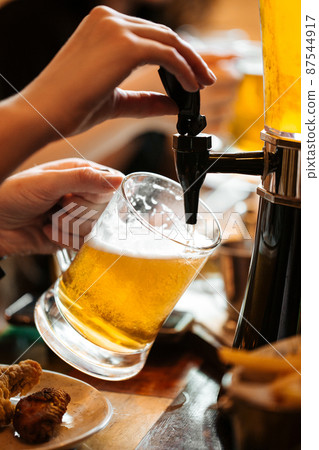 Hands pouring draught beer into a glass Hands pouring draught beer into a glass 87544917