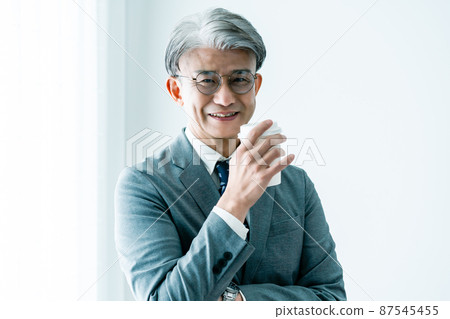 Middle-aged businessman doing a coffee break Middle-aged businessman doing a coffee break 87545455