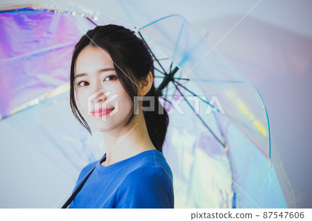 A woman holding an umbrella 87547606
