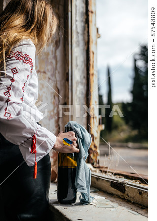 Molotov cocktail in the hands of a Ukrainian woman in embroidery 87548809