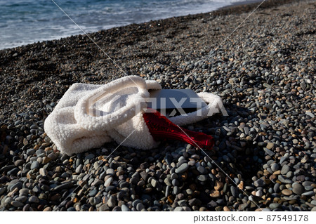 a bag with a laptop and a bottle of champagne lies on the coast of the sea 87549178