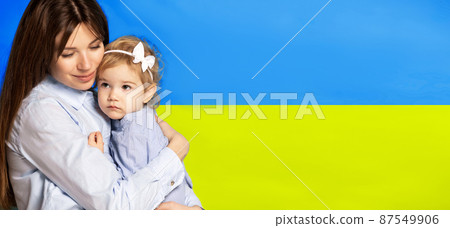 Portrait of young woman, mother with her little girl, daughter isolated over blue and yellow Ukrainian flag background. Flyer Portrait of young woman, mother with her little girl, daughter isolated over blue and yellow Ukrainian flag background. Flyer 87549906