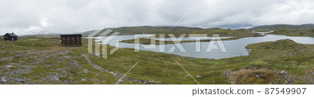 Panormaic view of mountain huts of STF Duottar fjallstuga cabin at Duottar lake. Artic tundra Lapland landscape Sweden at Padjelantaleden hiking trail. Summer moody sky 87549907