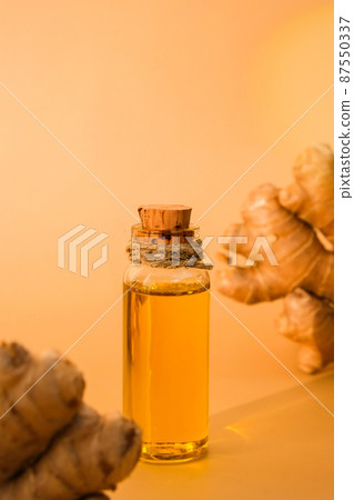 Glass bottle of essential ginger oil, ginger root on beige background. Healthy food eating concept. Zingiber officinale Essential oil. Natural cosmetics ingredients for skincare, body and hair care Glass bottle of essential ginger oil, ginger root on beige background. Healthy food eating concept. Zingiber officinale Essential oil. Natural cosmetics ingredients for skincare, body and hair care 87550337