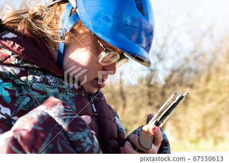 Outdoor portrait of a 39 year old white woman with the Down Syndrome having a call 87550613