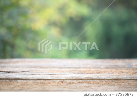 Wooden table surface with green nature background  87550672