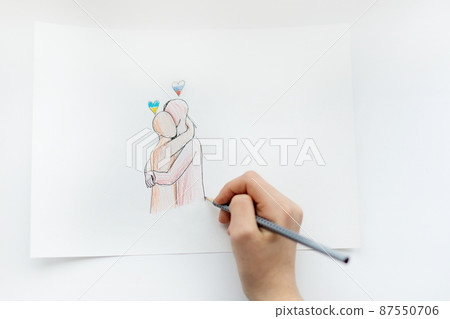 A child draws on a piece of paper two hugging people with a close-up drawing of two flags of Ukraine and Russia. View from above. No war A child draws on a piece of paper two hugging people with a close-up drawing of two flags of Ukraine and Russia. View from above. No war 87550706
