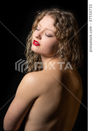 Studio Portrait of a 21 year old white blonde woman showing her naked back Studio Portrait of a 21 year old white blonde woman showing her naked back 87550710