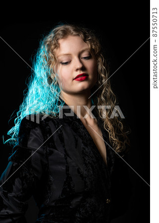 Glamour studio Portrait of a 21 year old white blonde woman with curling hair Glamour studio Portrait of a 21 year old white blonde woman with curling hair 87550713