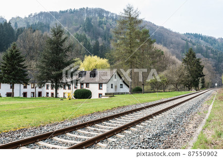 Auw an der Kyll, Rhineland-Palatinate - Germany -  Double bending railwaytrack in the foggy nature landscape along the Kyll creek valley 87550902