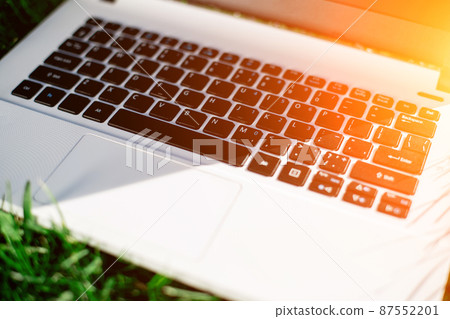 Laptop with blank screen on green lawn Laptop with blank screen on green lawn 87552201