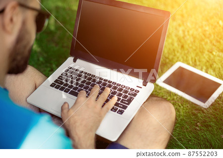 Top view male hands using notebook outdoors in urban setting while typing on keyboard, businessman freelancer working on computer. Top view male hands using notebook outdoors in urban setting while typing on keyboard, businessman freelancer working on computer. 87552203