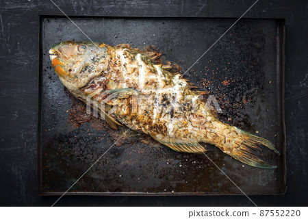 BBQ saltwater parrotfish as top view on an old black board with copy space 87552220