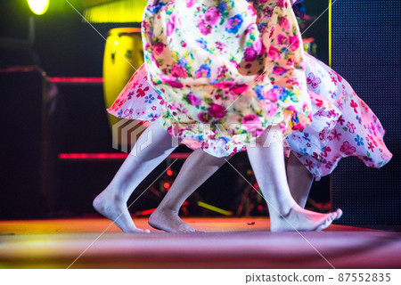 Young dancer woman barefoot in gypsy dress dancing on stage 87552835