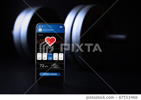 Gym app. Smartphone screen with sport gym or fitness health mobile application on black dumbbell background. App for training indoors. Gym app. Smartphone screen with sport gym or fitness health mobile application on black dumbbell background. App for training indoors. 87553466