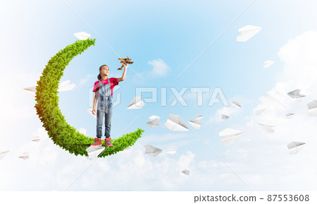 Concept of careless happy childhood with girl on green moon 87553608