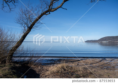 A beautiful lake view in the morning. A mist over the blue lake A beautiful lake view in the morning. A mist over the blue lake 87553653