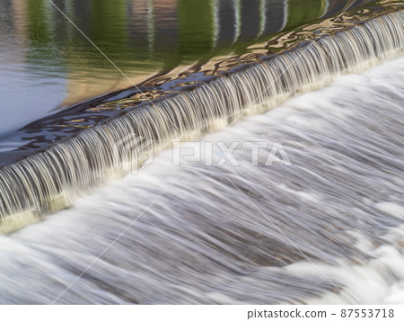 A small flat cascade in a calm river A small flat cascade in a calm river 87553718