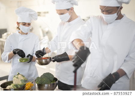 Multiracial team of chef cooks cooking together in the kitchen 87553927