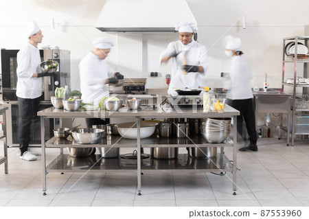 Chef cooks working in professional kitchen Chef cooks working in professional kitchen 87553960