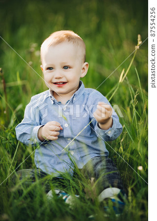 Portrait of stylish blonde little boy sitting in 87554256