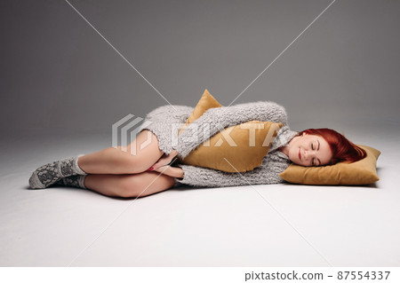 Studio portrait of a woman in a sweater hugging a 87554337