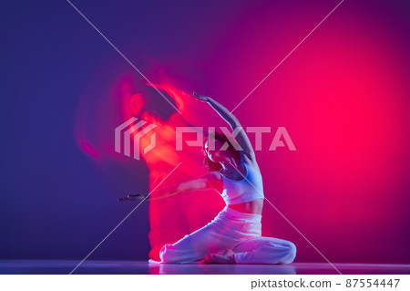 Young sportive beautiful girl, hip-hop dancer dancing hip hop isolated on purple background in pink neon light. Youth culture, style and fashion, action. 87554447