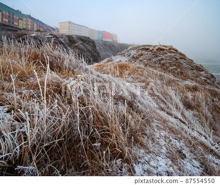 Autumn Arctic landscape. View of the colorful buildings of the port town on the coast. Autumn Arctic landscape. View of the colorful buildings of the port town on the coast. 87554550