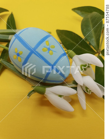 Colorful Easter egg and spring flowers on a yellow background. Easter greeting, postcard, copy space, easter decorations 87554788