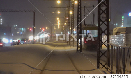 Winter night with a tram going into the distance Winter night with a tram going into the distance 87554855