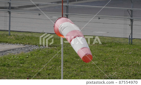 Frayed windsock in moderate wind on the airfield 87554970