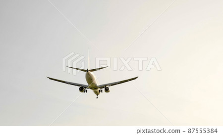 Commercial passenger airplane flying overhead on sunny day Commercial passenger airplane flying overhead on sunny day 87555384