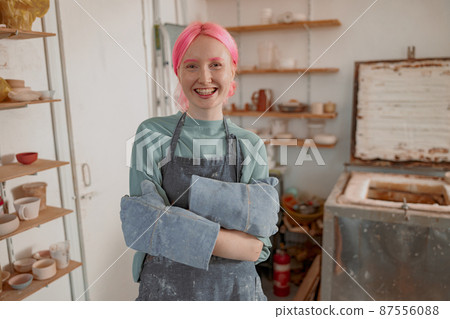 Young lady artisan ready for work in ceramic workshop Young lady artisan ready for work in ceramic workshop 87556088