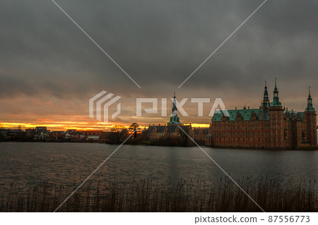 Frederiksborg castle on the sunset, with lake and tree in the foreground, Hillerod, Denmark Frederiksborg castle on the sunset, with lake and tree in the foreground, Hillerod, Denmark 87556773