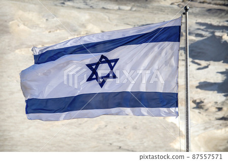Israel flag flying above desert backdrop in sunshine Israel flag flying above desert backdrop in sunshine 87557571