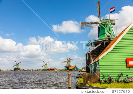 Colorful Windmills with Duthc flags at the river Zaan, Zaanse Schans, Zaandam, The Netherlands Colorful Windmills with Duthc flags at the river Zaan, Zaanse Schans, Zaandam, The Netherlands 87557670