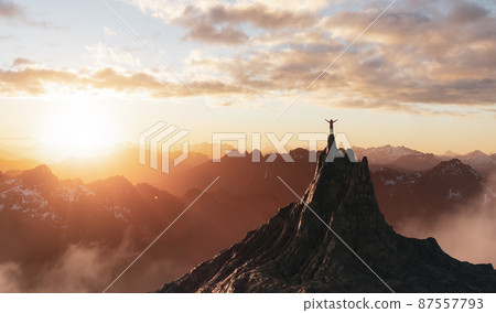 Adventurous Female person hiking on top of a mountain 87557793