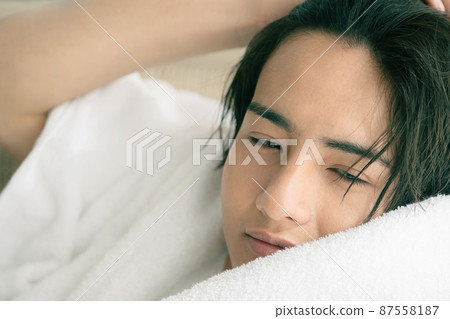 年輕人用毛巾擦乾濕頭髮 87558187